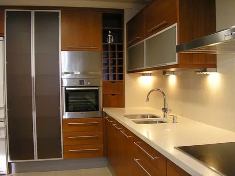 Una cocina con electrodomésticos de acero inoxidable y gabinetes de madera.
