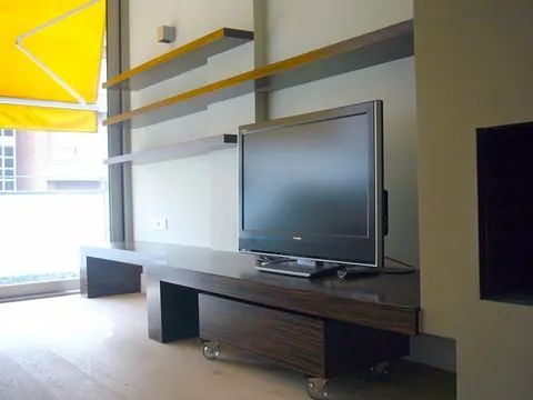 Un televisor de pantalla plana está sobre un centro de entretenimiento de madera.