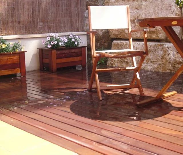 Una silla se encuentra en una terraza de madera junto a una mesa.