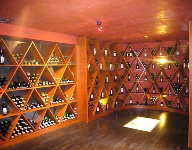 Una habitación llena de muchas botellas de vino en los estantes.