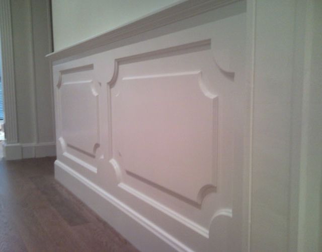 Una pared blanca con piso de madera en una habitación.