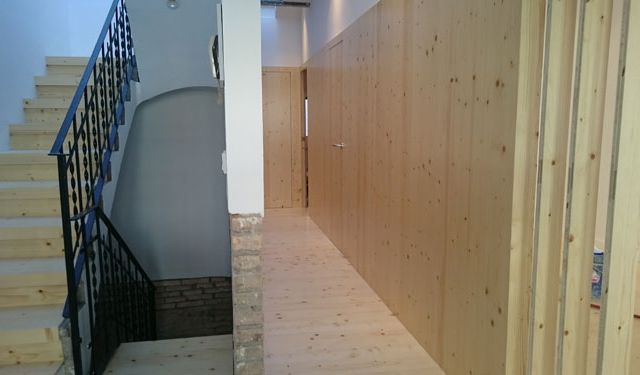 Un pasillo con paredes de madera y escaleras en un edificio.