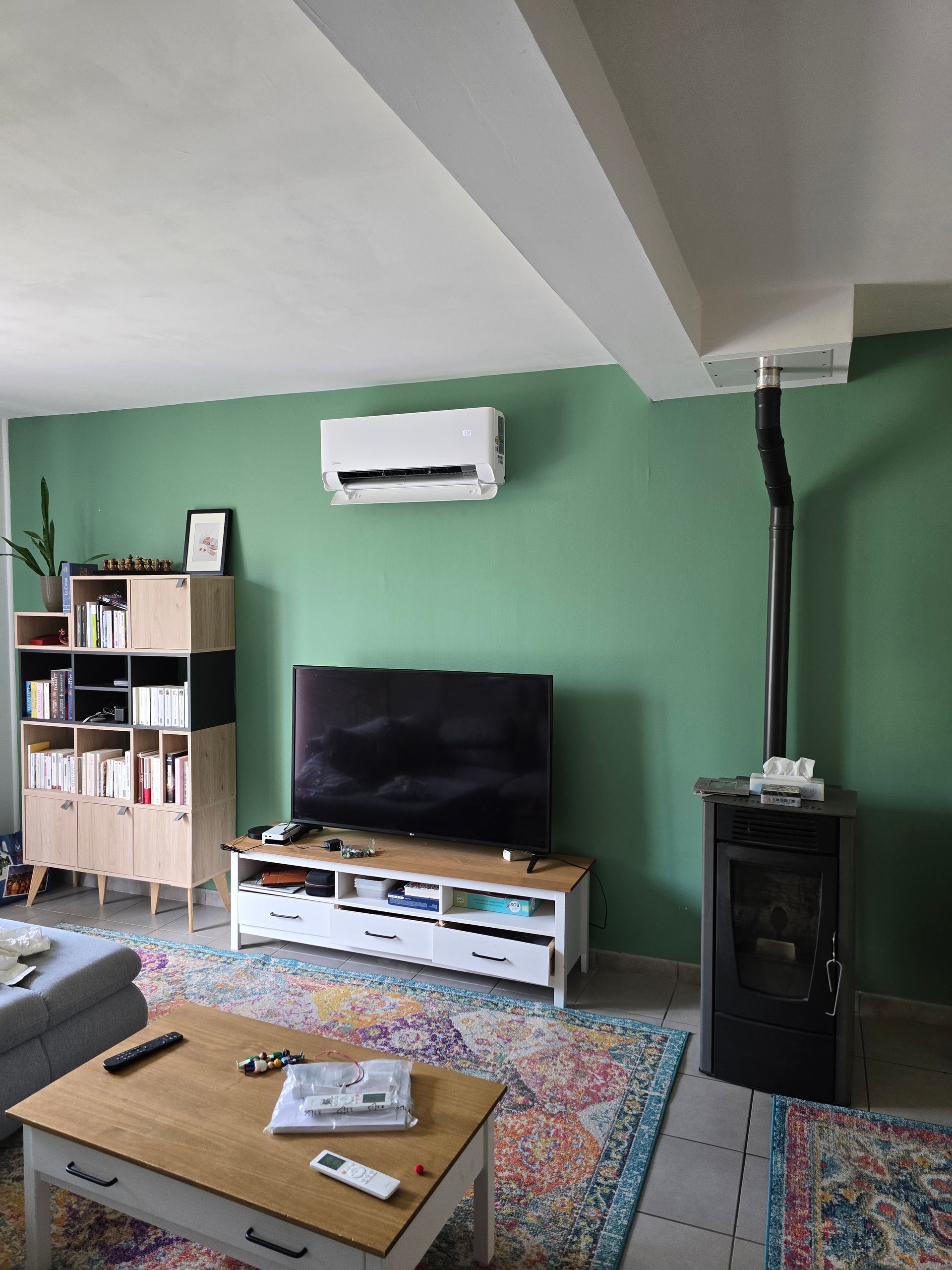 Climatisation dans salon au mur vert