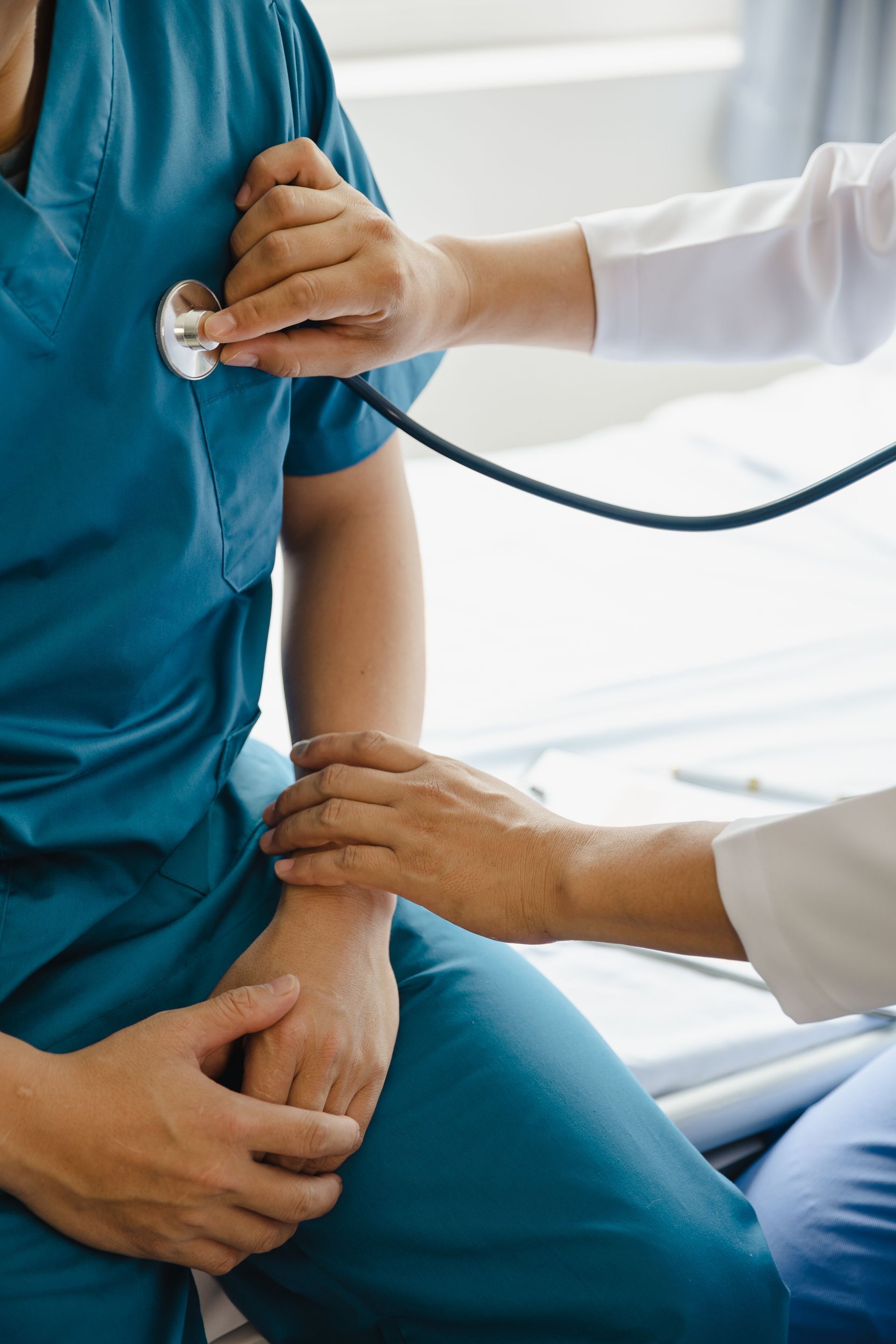 Person wird mit einem Stethoskop abgehört