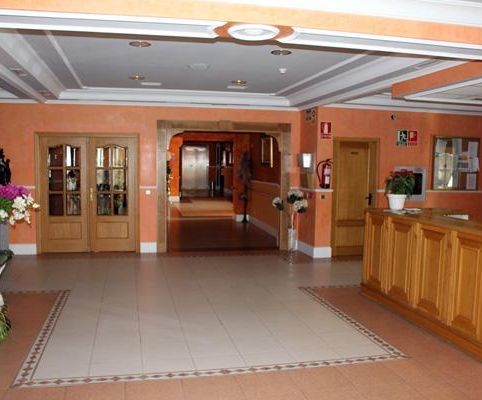 Un vestíbulo con un mostrador de madera y un extintor en la pared.