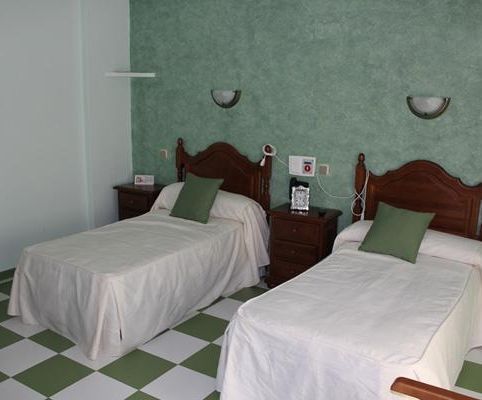 Un dormitorio con dos camas y suelo de cuadros.