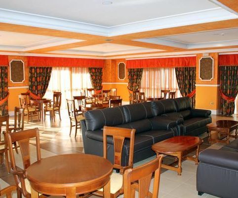 Una sala de estar con mesas y sillas y un sofá.