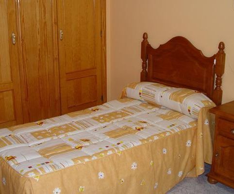 Un dormitorio con una cama individual y una mesita de noche.