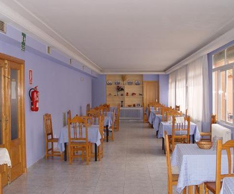 Un restaurante con mesas y sillas y un extintor en la pared.