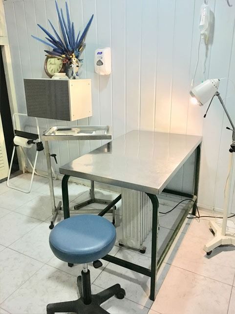 Una mesa de acero inoxidable con un taburete azul en una habitación.