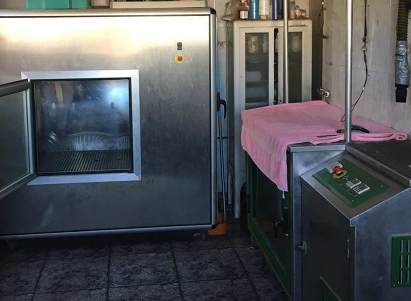 Una habitación con un refrigerador de acero inoxidable y una toalla rosa sobre una mesa.