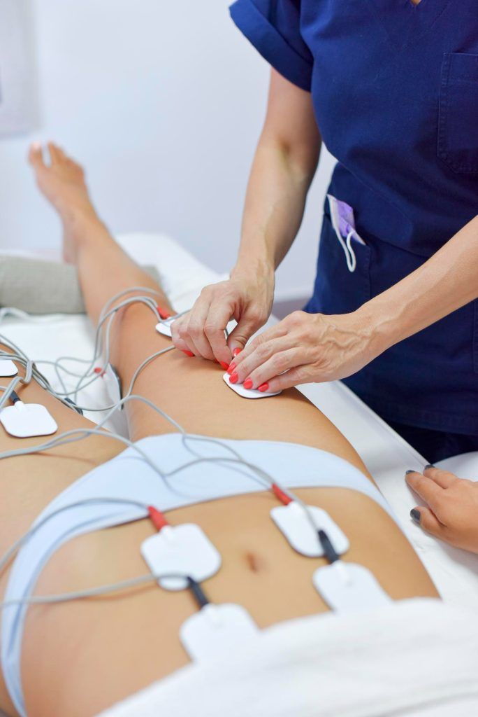Hombre con uniforme negro y brazos cruzados, de pie frente a un cartel de dentista.