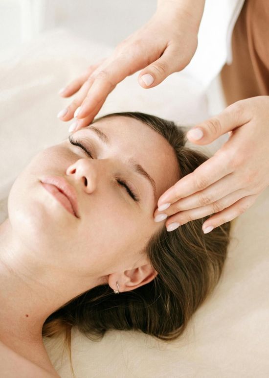 Sala de espera con sofá naranja, sillas únicas y planta en maceta.