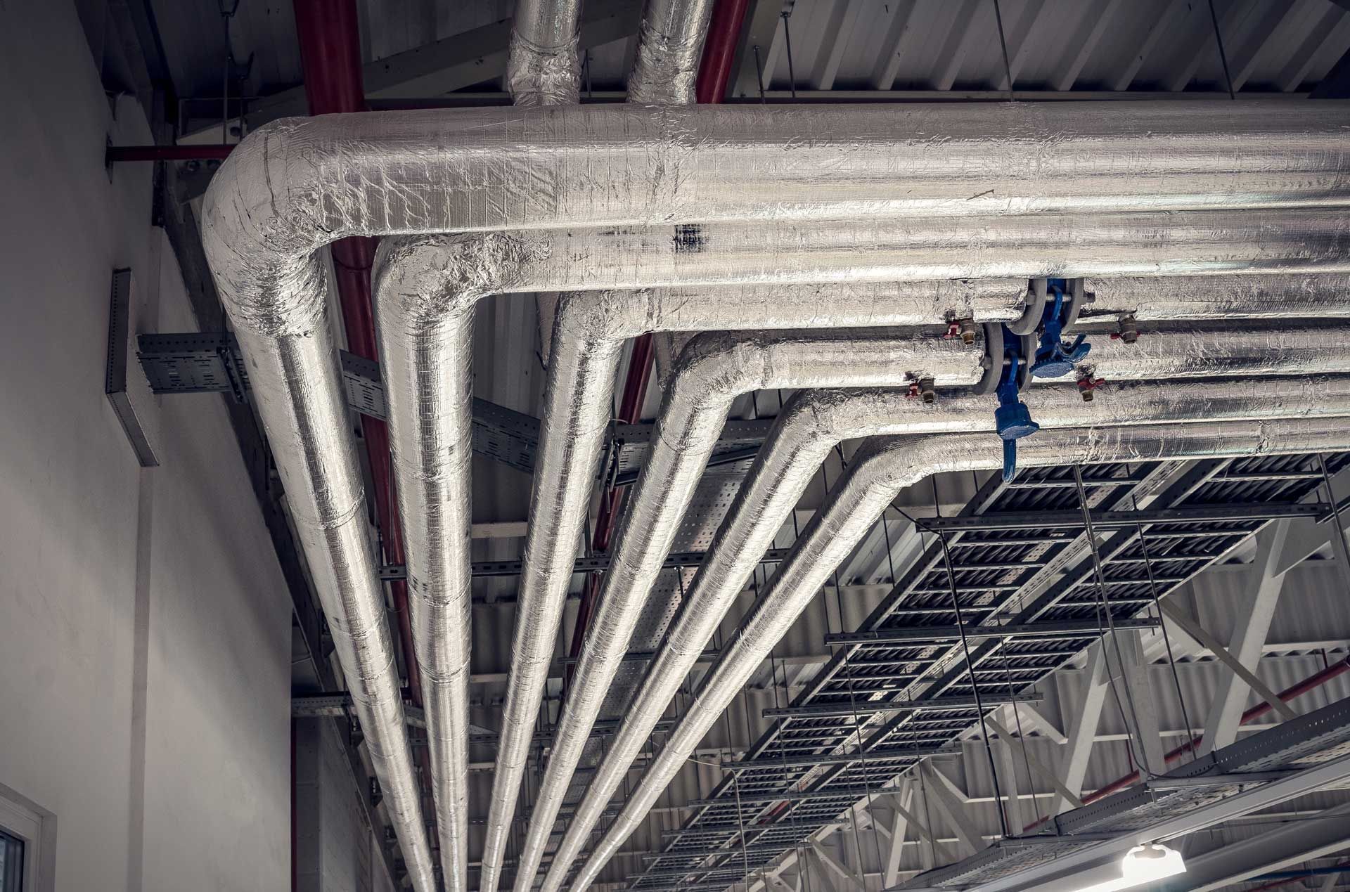 Tuyaux calorifugés au plafond d'un entrepôt