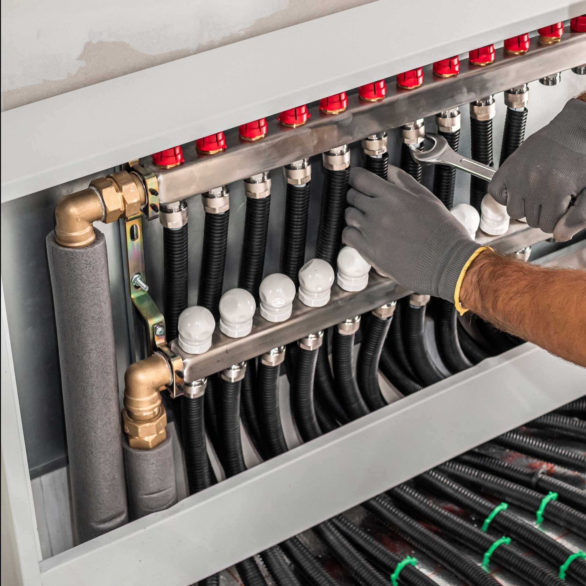 Intervention d'un chauffagiste sur les raccordements d'un plancher chauffant