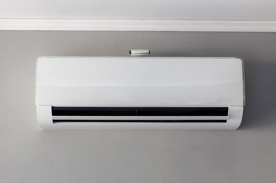 Un climatiseur mural blanc sur un mur gris.