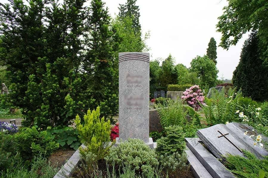 Ein Grab auf einem Friedhof mit einem Kreuz darauf