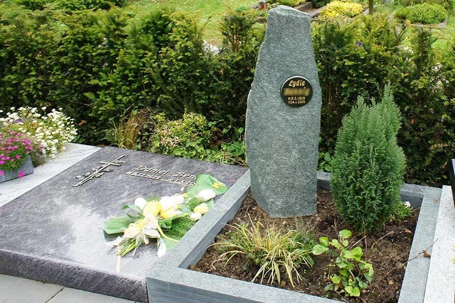 Ein Grab auf einem Friedhof mit einer Gedenktafel darauf