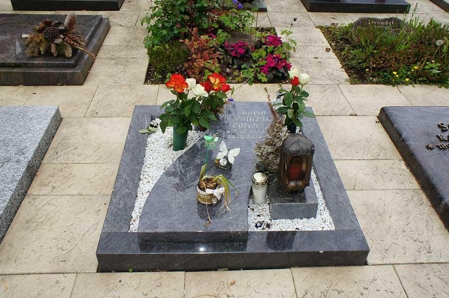 Ein Grab auf einem Friedhof mit Blumen und Kerzen