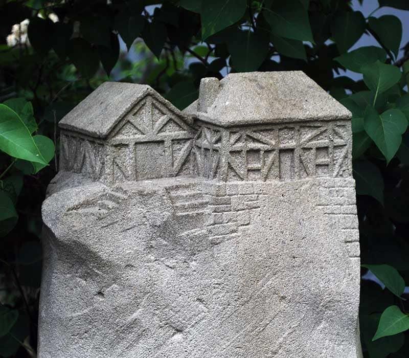 Eine Steinskulptur mit ein paar eingemeißelten Häusern