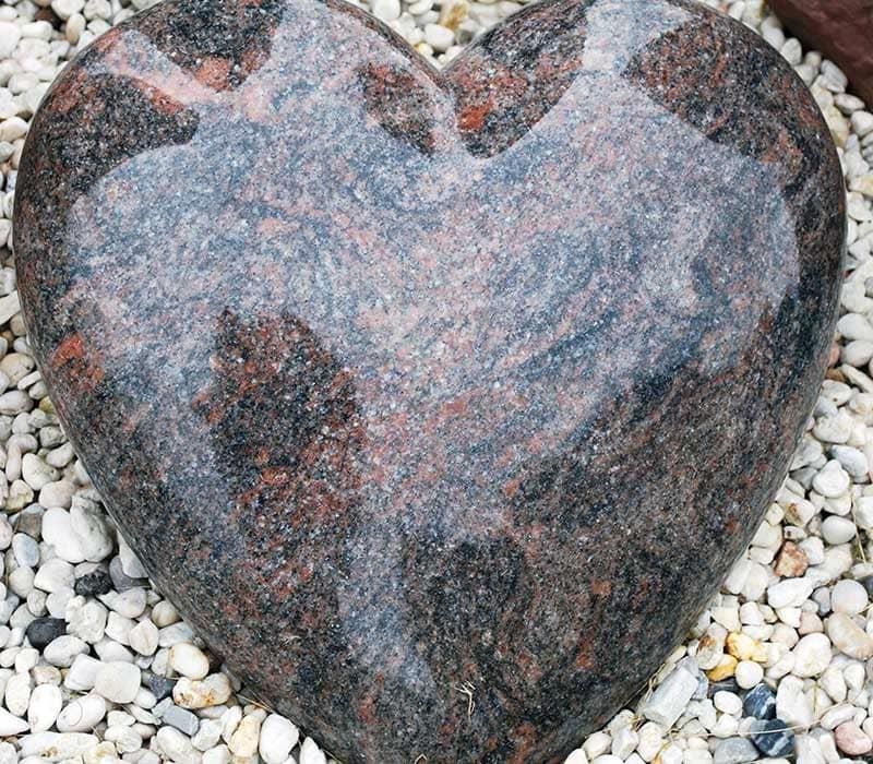 Auf einem Steinhaufen liegt ein herzförmiger Stein.