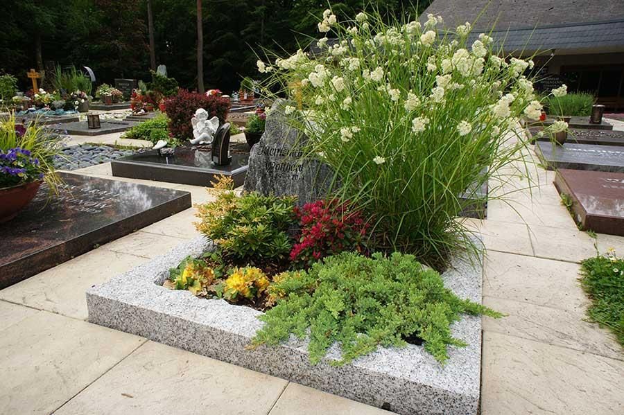 Ein Friedhof mit vielen Blumen und Pflanzen