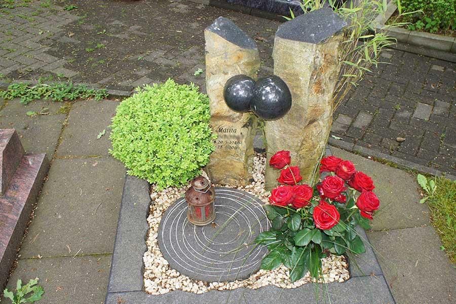 Ein Grab mit Blumen und einer Kerze darauf