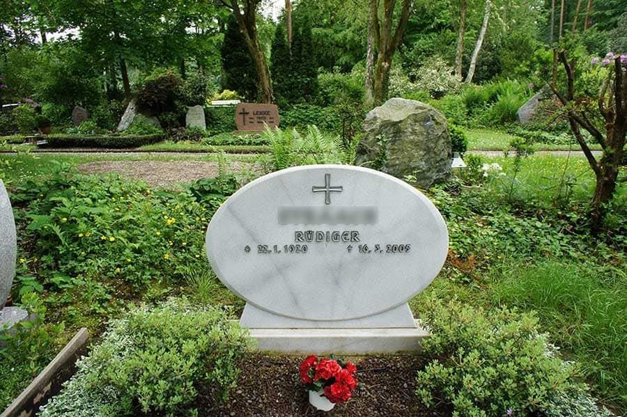 Ein Grab auf einem Friedhof mit einem Kreuz darauf