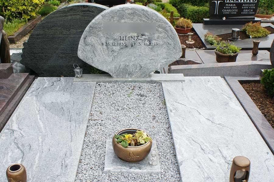 Ein Grab auf einem Friedhof mit einer Vase mit Blumen darauf