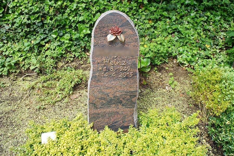Ein Grabstein auf einem Friedhof mit einem Pilz darauf.