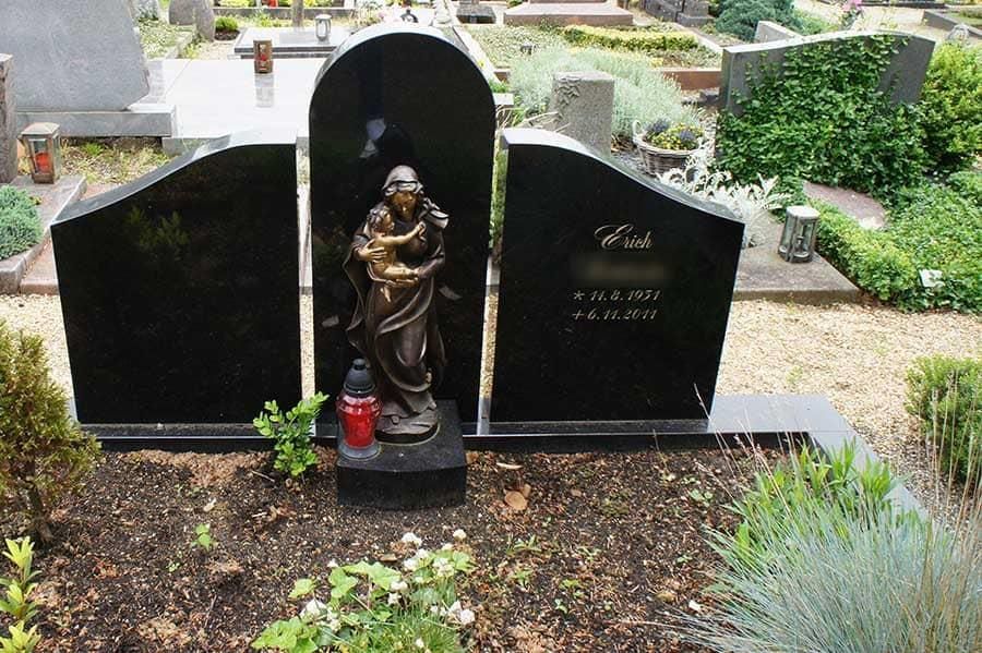 Ein Friedhof mit einer Statue einer Frau, die ein Kind hält