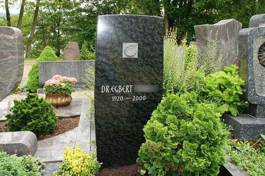 Ein Grabstein auf einem Friedhof mit einem darauf geschriebenen Namen