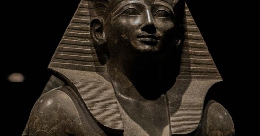 A majestic statue of an Egyptian pharaoh, with a serene expression and a distinctive headdress.