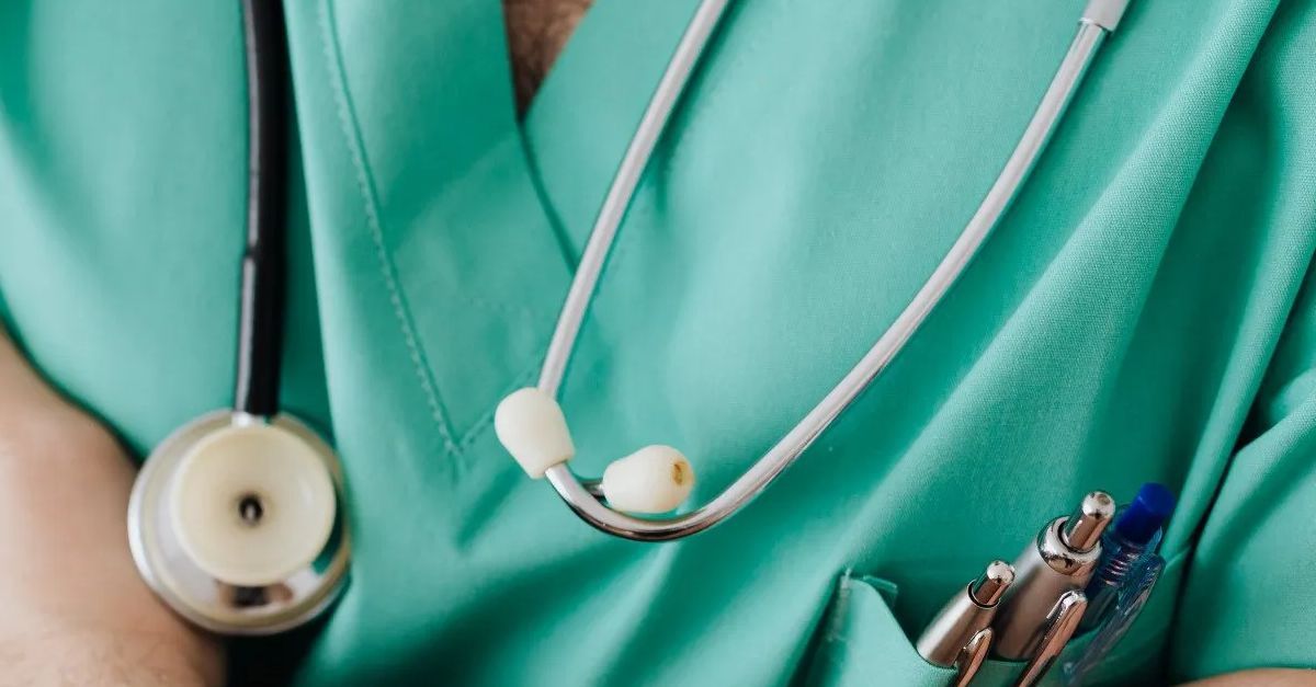 A dedicated Egyptian doctor, wearing a stethoscope and scrubs, patiently awaits patients in a clinic.