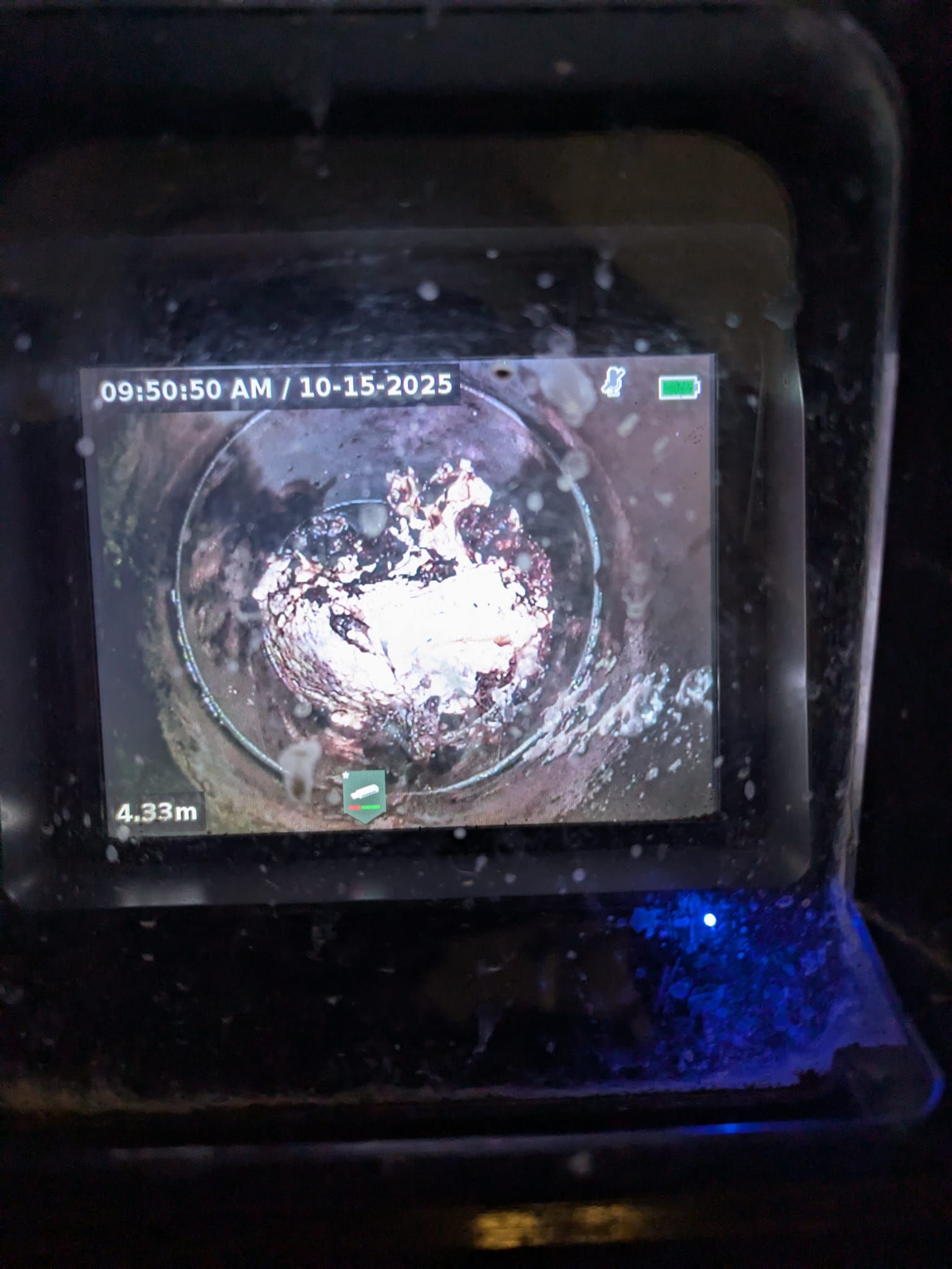 Tuberías y válvulas montadas en una pared oscura y texturizada; tuberías amarillas y grises.