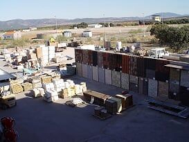 Un gran almacén lleno de muchas cajas y camiones.