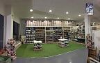 Una tienda con muchos estantes y una alfombra verde en el medio de la habitación.