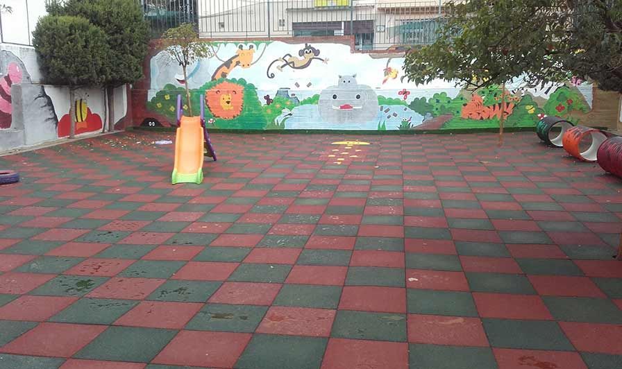 Un parque infantil con un tobogán y un mural en la pared.
