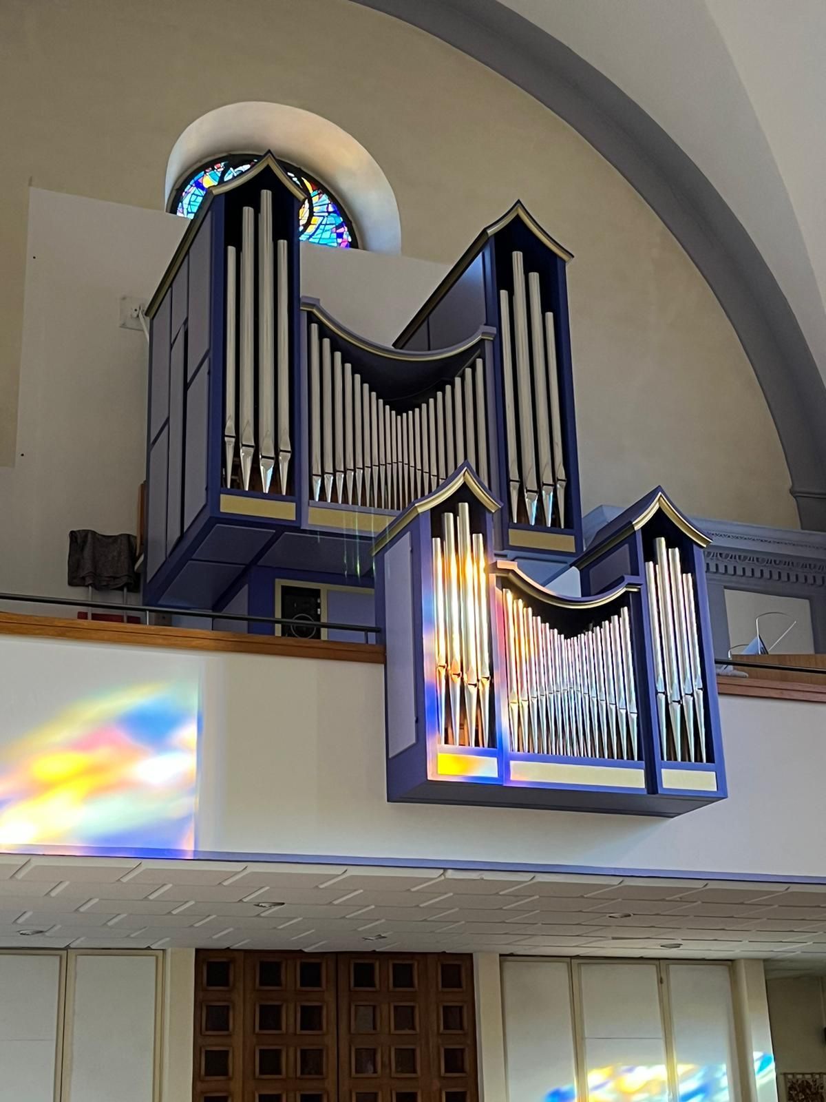 Une pièce avec beaucoup de fenêtres et une balustrade en bois.