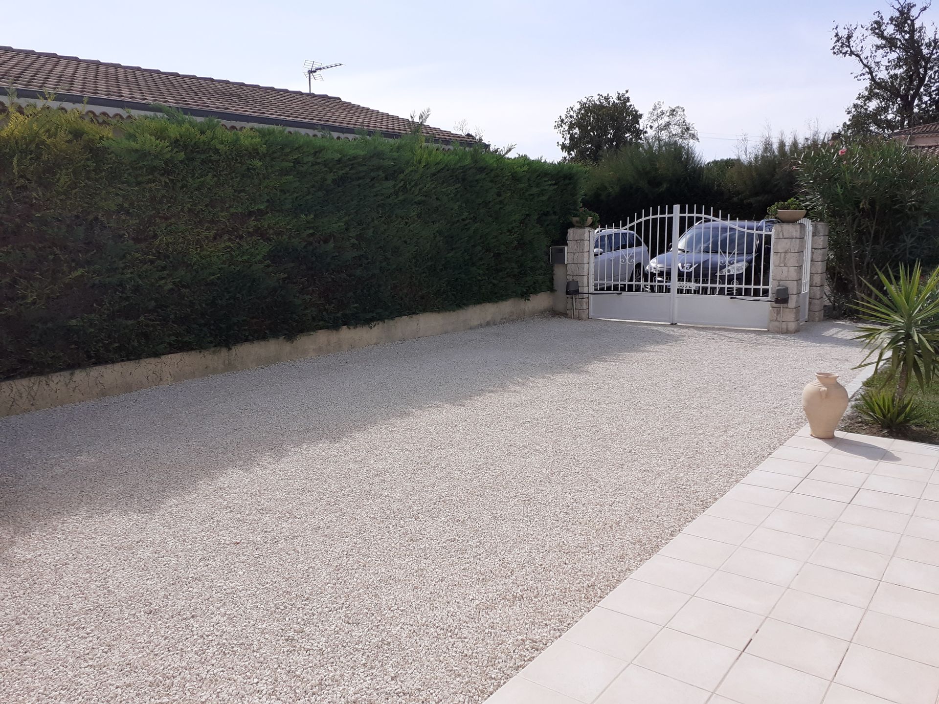 Une allée avec du gravier au sol