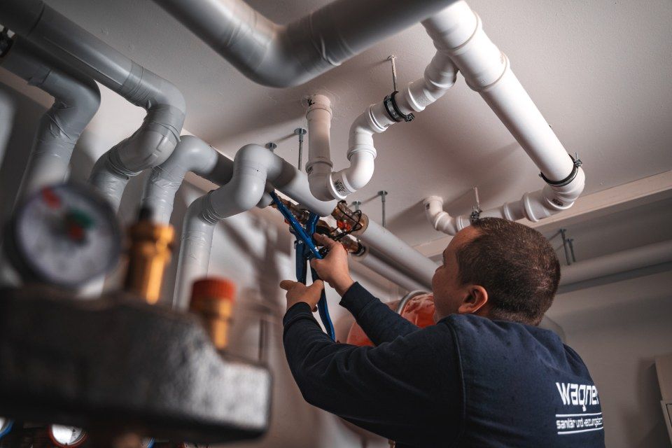 Günter Wagner GmbH – Techniker arbeitet mit Werkzeug an Deckenrohren