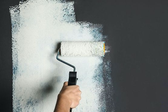 Breite Garage mit dunklem Tor und dunkler Haustür