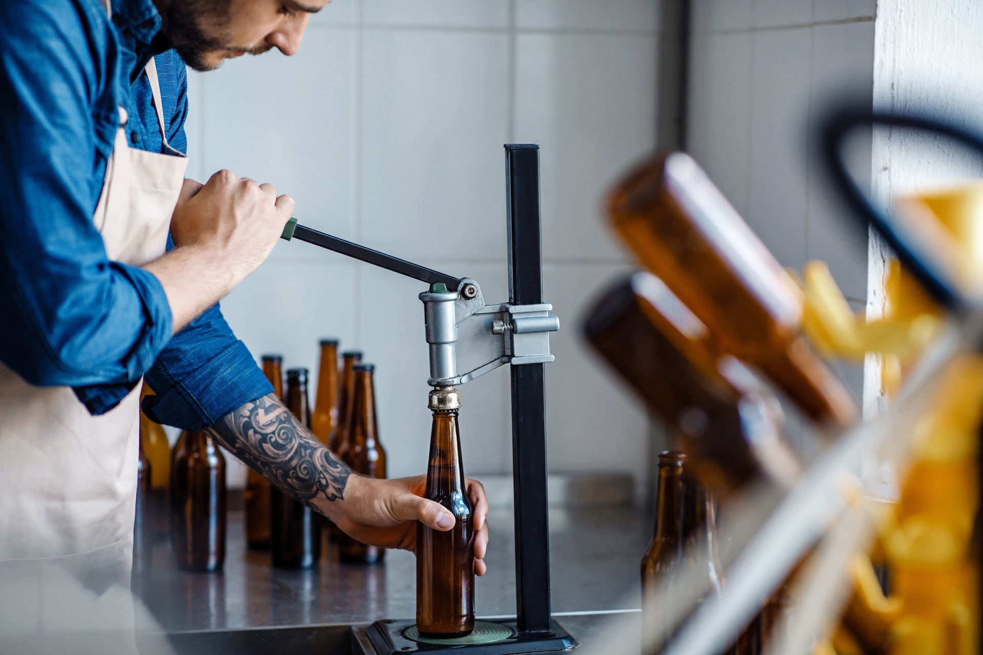 Ouvrier remplissant des bouteilles brunes sur une chaîne de production dans la cuisine d’une usine