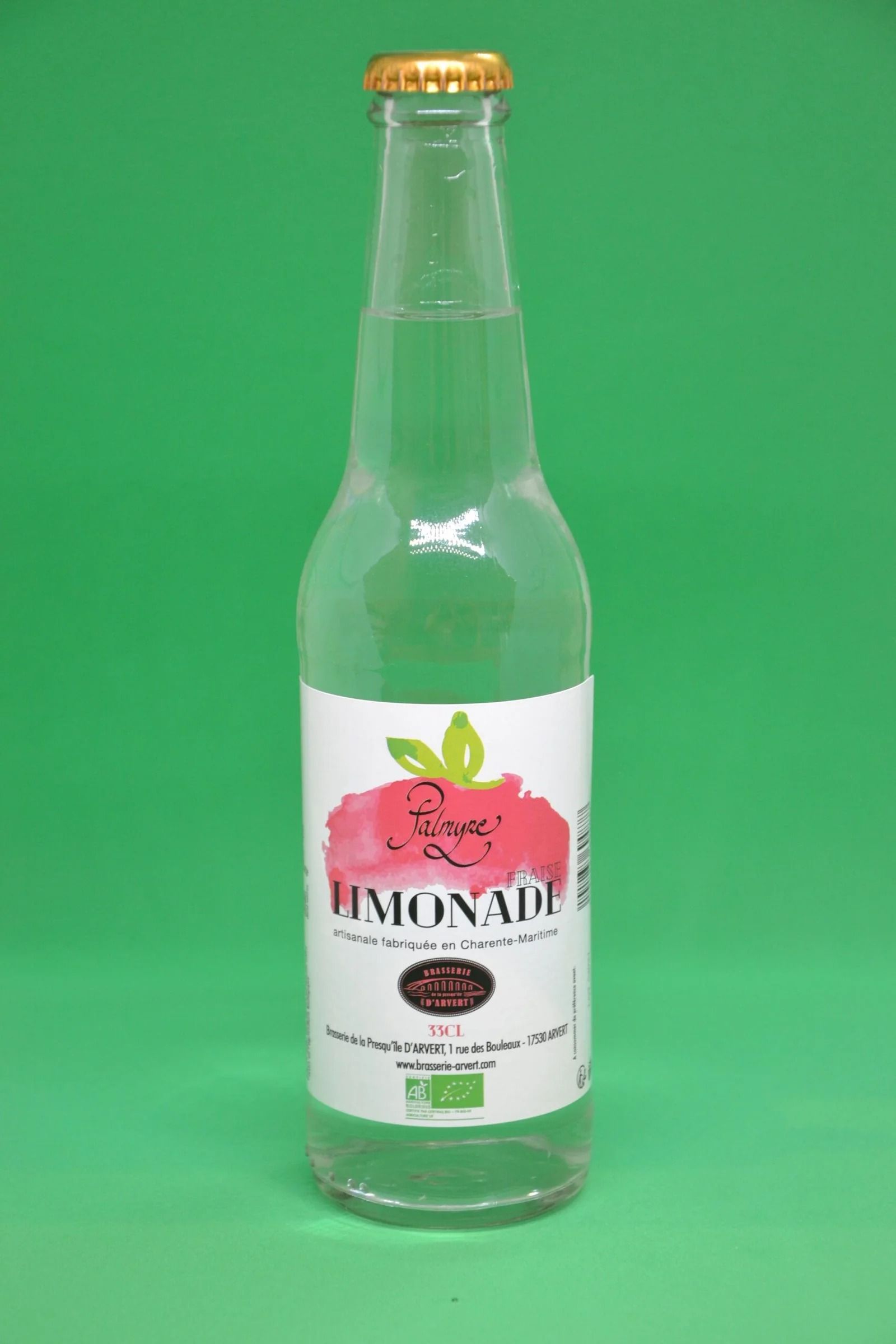 Bouteille en verre transparent de soda citron-citron vert, avec une étiquette blanche et un bouchon doré, sur fond vert