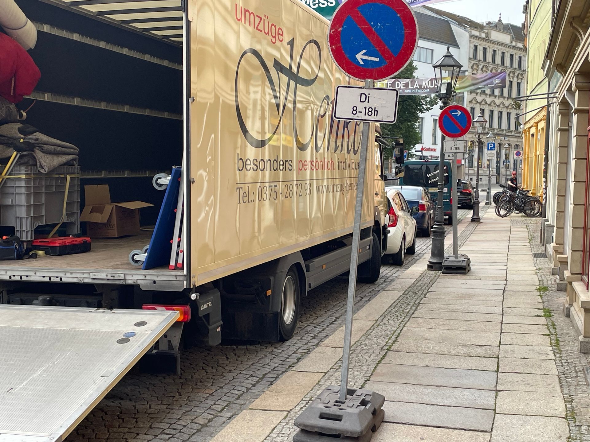 Umzugswagen wird in einer engen Straße beladen.