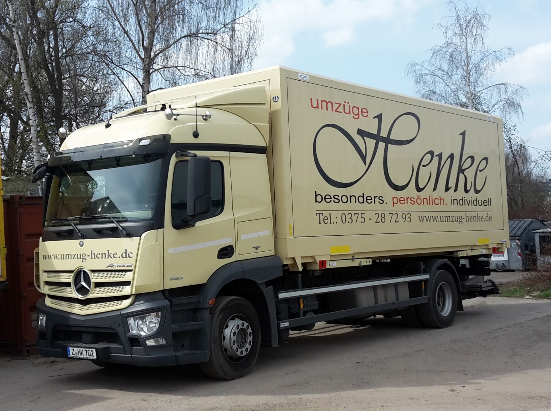 Umzugs-LKW mit Firmenlogo auf einem Parkplatz.
