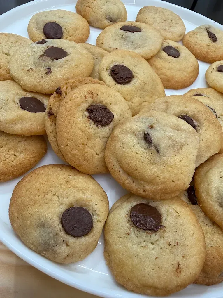 Plato de galletas variadas con chispas de chocolate en un plato blanco.