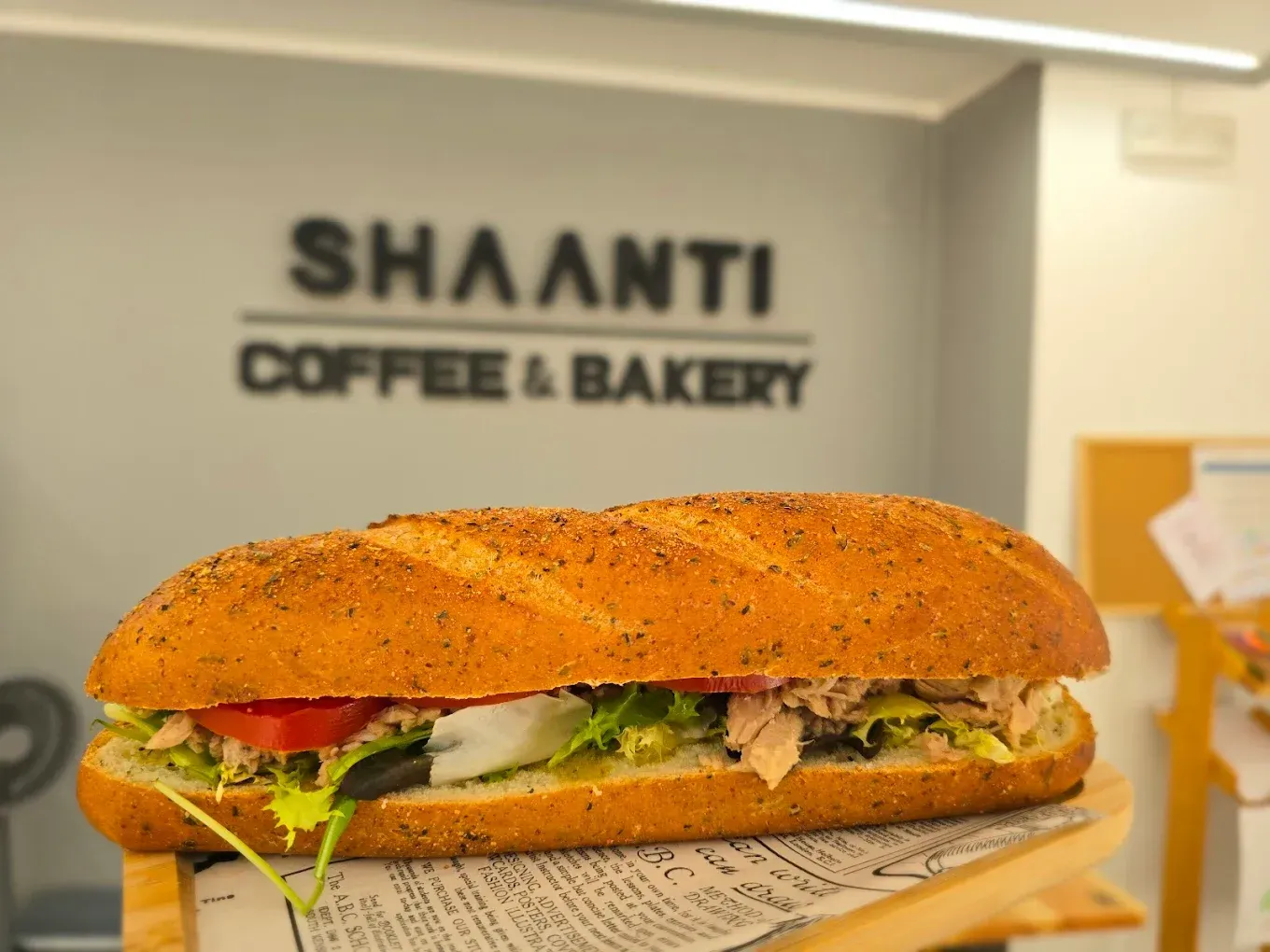 Un sándwich en una bandeja frente al mostrador de SHANTI Coffee & Bakery.