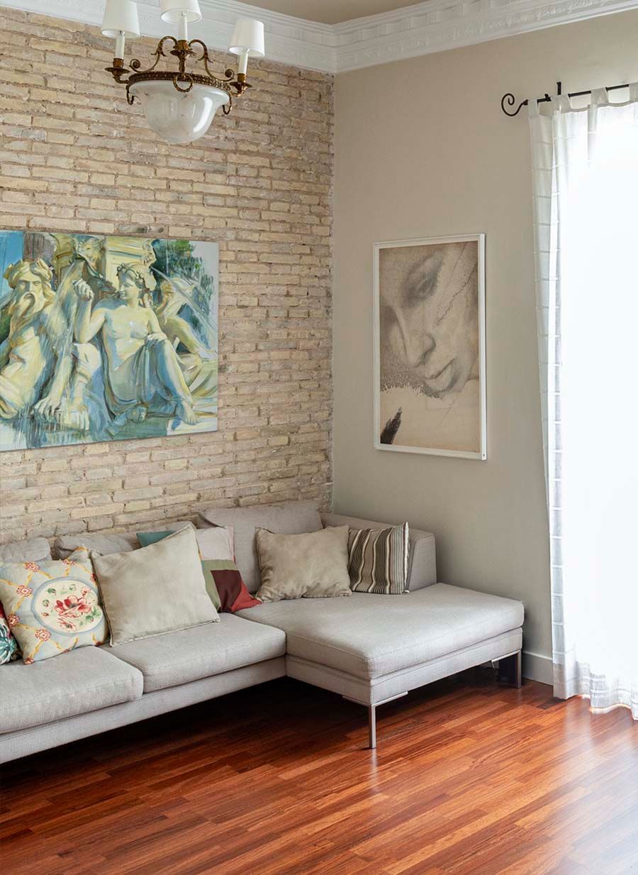 Una sala de estar con un sofá y un cuadro en la pared.