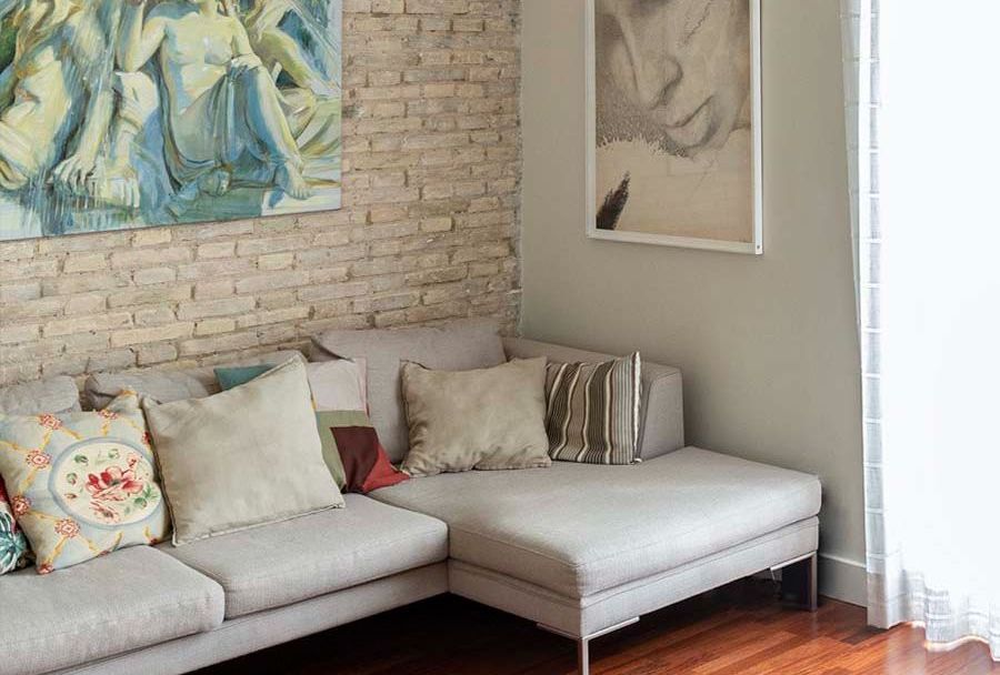 Una sala de estar con un sofá y un cuadro en la pared.